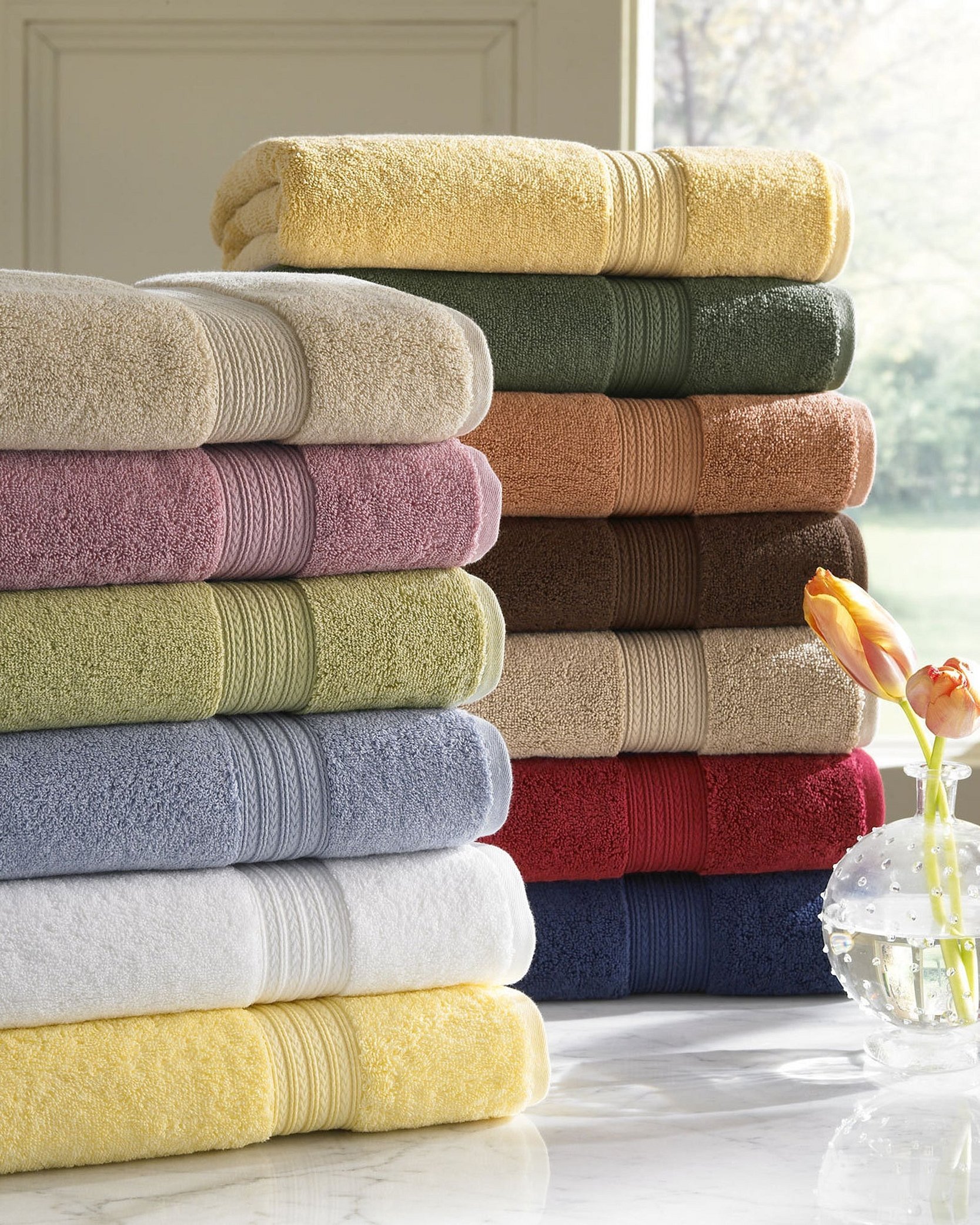 Какие полотенца выбрать. Цветные полотенца. Стопка полотенец. Полотенца махровые в интерьере. Мягкое полотенце круглое.