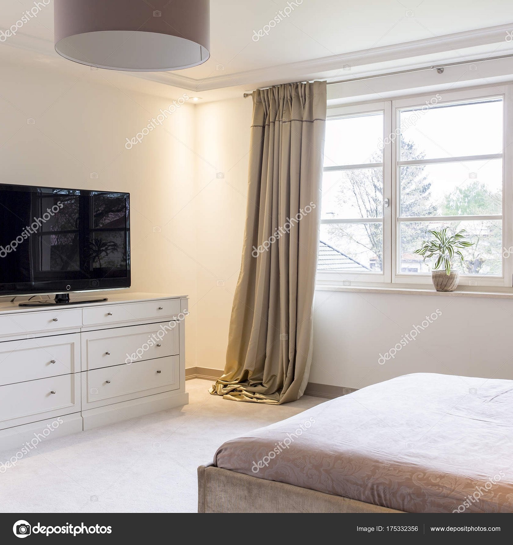 Светлая спальня с высоким комодом под телевизор