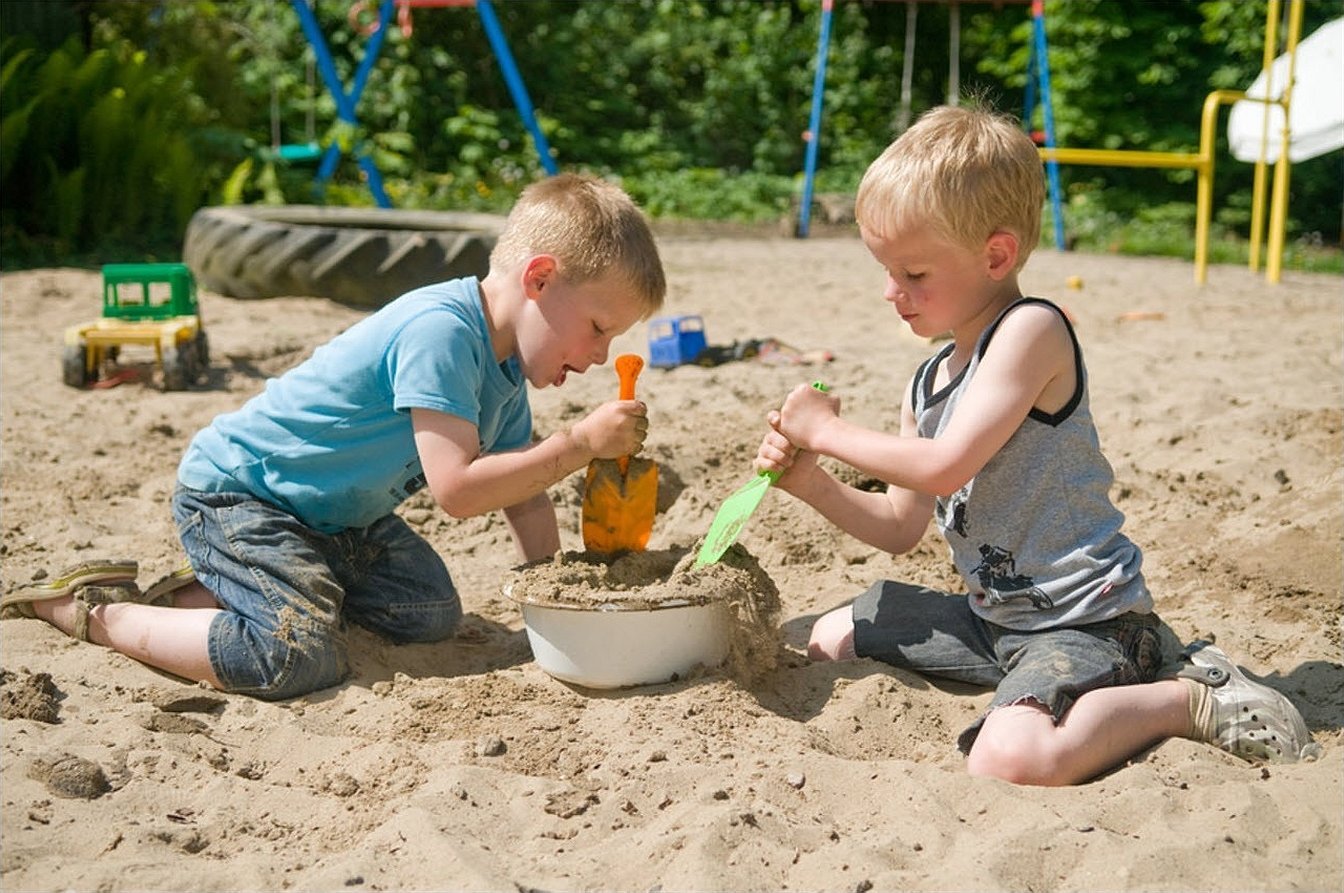 Мальчик с девочкой в песочнице играют
