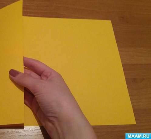 Лист желтой цветной бумаги пополам
